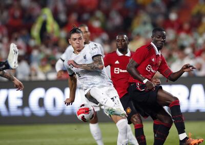 El uruguayo Darwin Núñez (i), del Liverpool, disputa el balón con Eric Bailly, defensor de Manchester United, durante el partido amistoso de ayer en Bangkok.