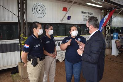 El cónsul en Posadas, Rolando Agustín Goiburú, conversa con la subcomisario Deolinda Lezcano, jefa regional Ciudad del Este del departamento de Trata de Personas de la Policía Nacional y agentes de dicha unidad, en el centro de fronteras de Encarnación, tras la restitución de la menor de 15 años retenida en la Argentina.