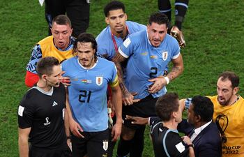 Los futbolistas de la selección uruguaya reclamando al árbitro alemán Daniel Siebert (C) tras el partido ante Ghana en el Mundial de Qatar 2022.
