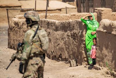 Una mujer y un niño observan a un soldado estadounidense durante un patrullaje en Rumaylan, en el norte de Siria.