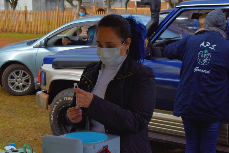 Personal de blanco del Hospital Regional de Villarrica preparando las dosis anticovid para la inoculación.