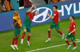 El delantero portugués #07 Cristiano Ronaldo celebra con sus compañeros después de anotar el primer gol de su equipo desde el punto de penalti durante el partido de fútbol del Grupo H de la Copa Mundial Qatar 2022 entre Portugal y Ghana en el Estadio 974 en Doha el 24 de noviembre de 2022.