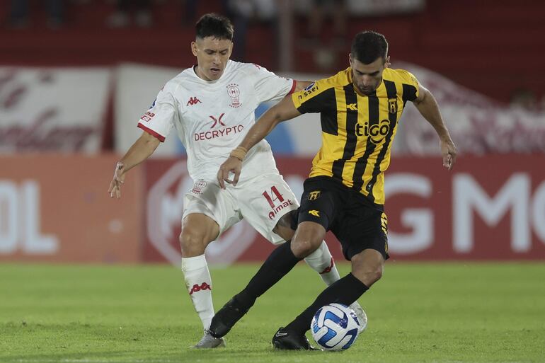 Guillermo Benitez (i) de Huracán disputa un balón con Raúl Alejandro Cáceres de Guaraní, en un partido de la fase de grupos de la Copa Sudamericana entre Huracán y Guaraní en el estadio Tomás Adolfo Ducó, en Buenos Aires (Argentina).