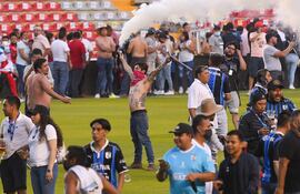 La pelea entre hinchas de ambos equipos, iniciada en las gradas, creció y fue a parar al terreno.