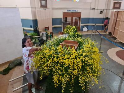 Idalina Hermosilla da los últimos retoques al arreglo del pedestal de la imagen de la Virgen de los Milagros de Caacupé. Este año, las flores elegidas son de orquídeas amarillas que florecen esta temporada. Además follaje de clavitos y hojas perennes.