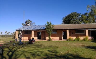 Dos personas trabajan en el arreglo del techo del  Colegio Nacional “Jacinto Colarte” de la compañía Carolina.