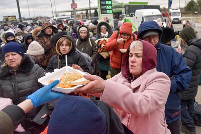 Los refugiados de guerra de Ucrania reciben alimentos en el cruce fronterizo ucraniano-polaco Krakowiec-Korczowa, Polonia.