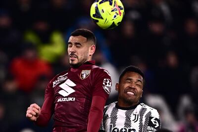 El paraguayo Antonio Sanabria, delantero del Torino, cabecea el balón superando en el salto al brasileño Alex Sandro, defensor de Juventus, durante el partido de ayer.