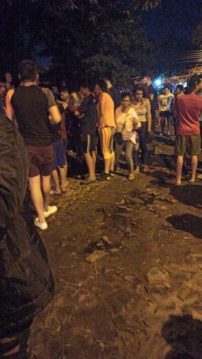 Personas reunidas alrededor del sitio del crimen, este sábado en Lambaré.