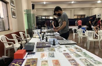 Un grupo de jóvenes observan los billetes históricos de Paraguay en la expo.