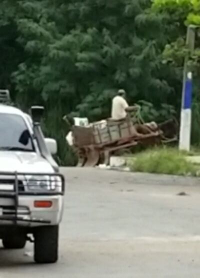 Carritero en el momento en que arroja basura al arroyo