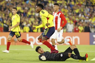Jorge Cabezas (arriba) de Colombia choca con Ángel González arquero de Paraguay tras anotar un gol hoy, en un partido de la fase final del Campeonato Sudamericano Sub'20 entre las selecciones de Colombia y Paraguay en el estadio El Campín en Bogotá (Colombia).