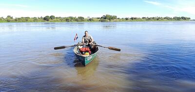 Don Eduardo Ruiz Díaz surca el río Paraguay en una embarcación a remo.