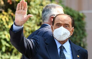 En esta foto de archivo tomada el 14 de septiembre de 2020, el ex primer ministro italiano Silvio Berlusconi saluda al salir del Hospital San Raffaele en Milán.