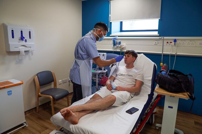 El enfermero Elia Sarno toma la temperatura al paciente Chay Godfrey, internado el hospital Wexham Park, cerca de Slough, al oeste de Londres.