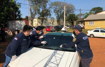 Agentes del Departamento de Criminalística de la Policía Nacional verifican el automóvil.