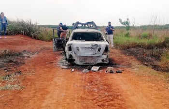 Efectivos de la Policía y agentes del Ministerio Público verifican el auto en que aparentemente fueron tomados las víctimas. El vehículo fue abandonado y quemado en Coronel Bogado.