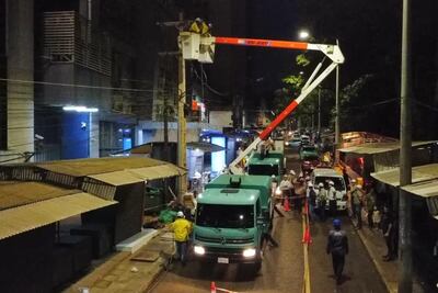 Dos operarios de la ANDE proceden a retirar los cables aéreos sobre la avenida Monseñor Rodríguez.