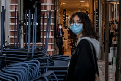 Una mujer con mascarilla cerca de un comercio cerrado en el centro de Lisboa, Portugal.