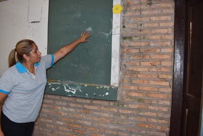 La Profesora Elizabeth Ferreira,  muestra las enormes grietas en las paredes de la escuela Oñondivepa de la ciudad de San Antonio.