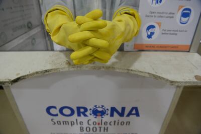 Un médico ataviado con su equipo de protección personal espera pacientes para recoger muestras en busca de coronavirus.