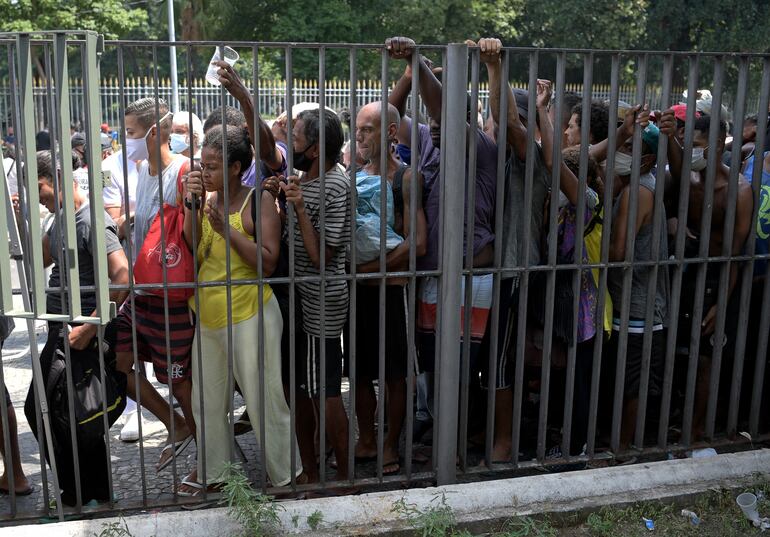 Mujeres embarazadas, ancianos y niños forman fila para recibir comida en Río de Janeiro, Brasil.