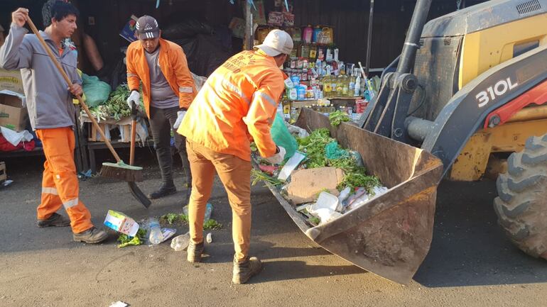Con la ayuda de tractores los personales de Aseo Urbano de San Lorenzo iban juntando los desechos que quedaron en el mercado.