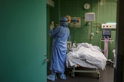 Un paciente con Covid internado en una Unidad de Terapia Intensiva recibe asistencia de un médico.