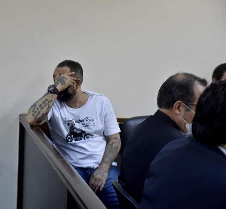 El brasileño Bruno Henrique dos Reis oculta su rostro, durante un receso del juicio oral y público por homicidio doloso.