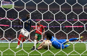 El francés Randal Kolo Muani empuja el balón hacia la redes para el segundo gol pese a la estirada del arquero Yassine Bono.