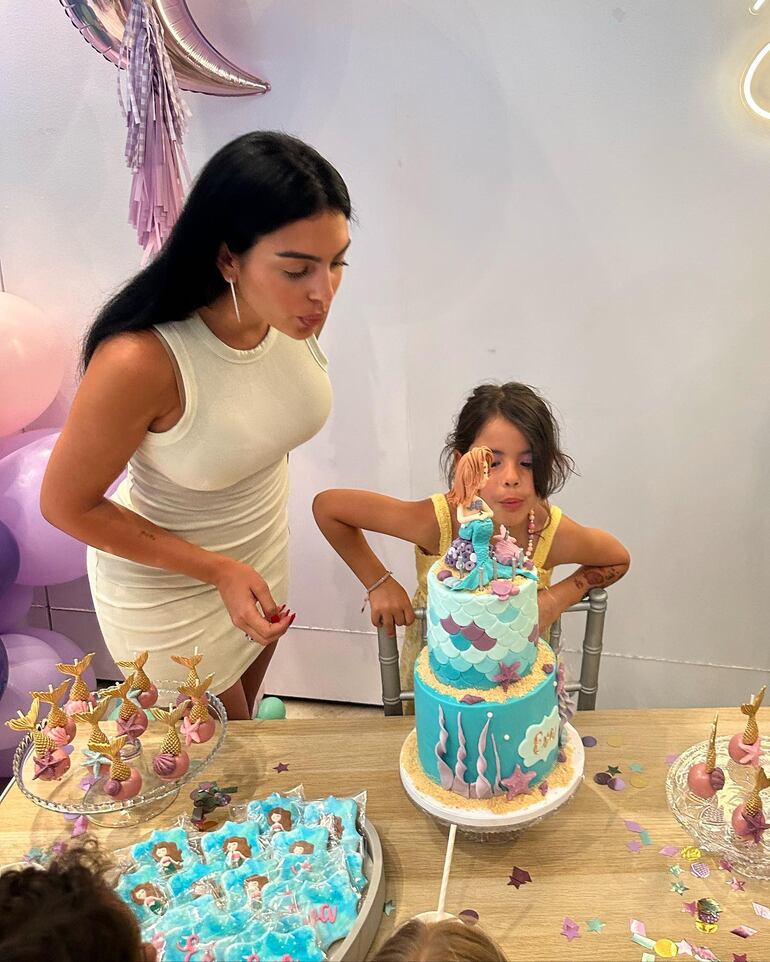 Mamá Georgina Rodríguez ayudando a Eva a apagar las velitas de la torta. (Instagram/Georgina Rodríguez)