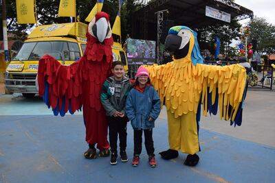 Niños posan junto a las mascotas del Festival del Gua´a, Lori y Lolo.