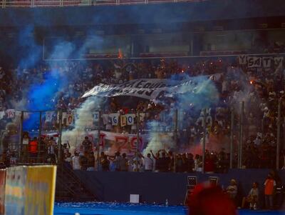 Momento en que la hincha de Olimpia enciende las bengalas de humo.