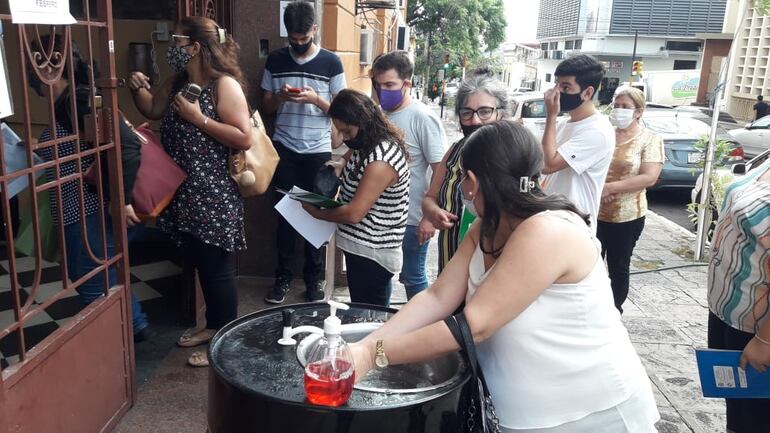 Padres y madres forman fila en la vereda del colegio nacional Asunción Escalada, para inscribir a sus hijos, en el primer día de apertura de la institución educativa, para trámites administrativos.
