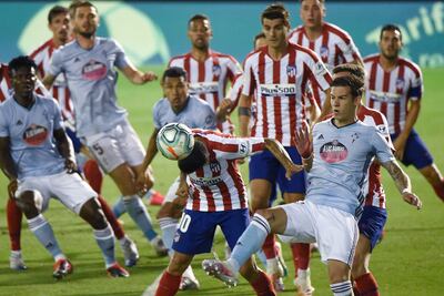 Atletico Madrid's Argentinian forward Angel Correa (C) heads te ball next to Celta Vigo's Spanish forward Santi Mina during the Spanish League football match between Celta Vigo and Atletico Madrid at the Balaidos stadium in Vigo on July 7, 2020. (Photo by MIGUEL RIOPA / AFP)