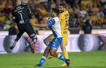 Andre gignac (d) de Tigres disputa el balón con Diego De Buen (c) y Antony Silva (i) portero de Puebla, durante el partido correspondiente al repechaje del Torneo Clausura 2023 del fútbol mexicano, disputado en el estadio Universitario de la ciudad de Monterrey (México). EFE/Miguel Sierra