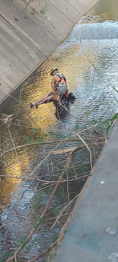 Un bombero voluntario se prepara para sacar el cuerpo sin vida de Miguel Angel Gayozo Segovia del cauce del arroyo Itay.