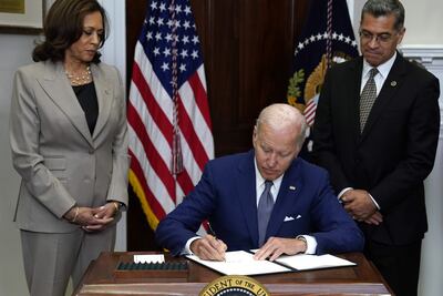 El presidente de los Estados Unidos, Joe Biden (C), firmando una orden ejecutiva que protege el acceso a los servicios de salud reproductiva en la Sala Roosevelt de la Casa Blanca en Washington, DC.