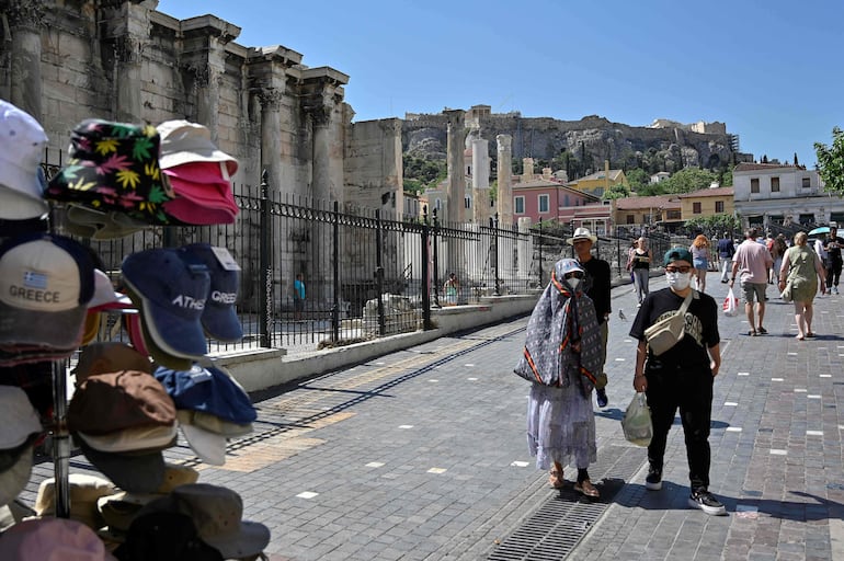 Visitantes recorren el área turística de Atenas.