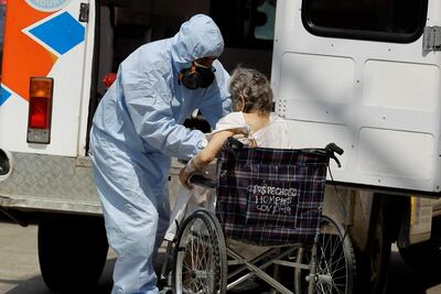 Un trabajador de la salud transporta a una mujer en silla de ruedas en el Hospital San Felipe, hoy, en Tegucigalpa (Honduras).