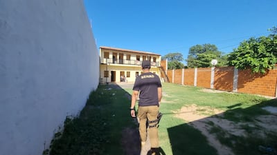 Un agente de la Senad entra a una de las propiedades allanadas en Mariano Roque Alonso.