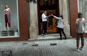 Varios empleados revisan el pasaporte covid en una tienda en Atenas, en una imagen de archivo.