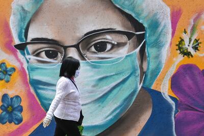 Una mujer camina junto a un mural pintado por el artista urbano Alejandro Bautista Torres, 38, conocido como Kato, en ciudad de México.