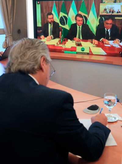 El presidente de Argentina, Alberto Fernández (de espaldas), durante una reunión virtual con su par de Brasil, Jair Bolsonaro (centro, en la pantalla), este lunes.