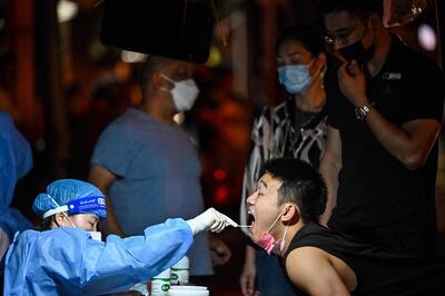Trabajadores de la salud realizan test de covid en la localidad de Huangpu, distrito de Shanghai. (AFP)