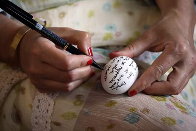 Una mujer escribe su mensaje en un huevo durante la peregrinación anual a El Ghriba, para conmemorar el día sagrado de Lag B'Omer.