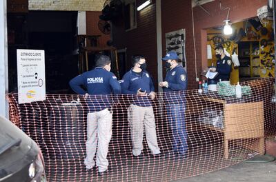 Agentes policiales intercambian datos sobre el crimen en la casa de repuestos de Fernando de la Mora.