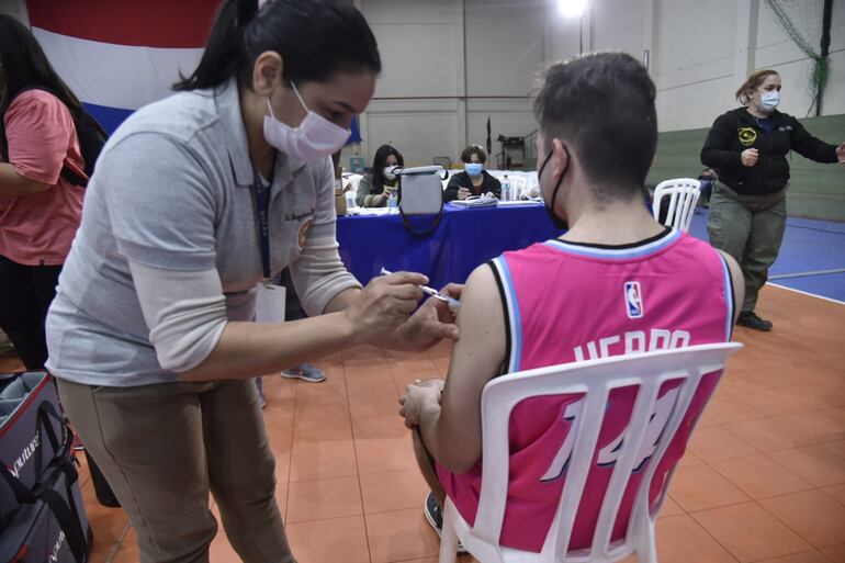 Un joven recibe una vacuna contra el COVID-19 en el llamado "Día A", para niños y jóvenes de entre 12 a 17 años en la sede de la Secretaría Nacional de Deportes.