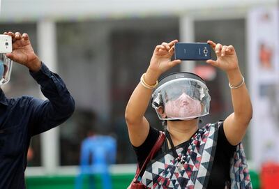 Una familia india usa cara protectora y máscaras mientras visitan un pandal improvisado durante el festival Durga Puja en Kolkata.