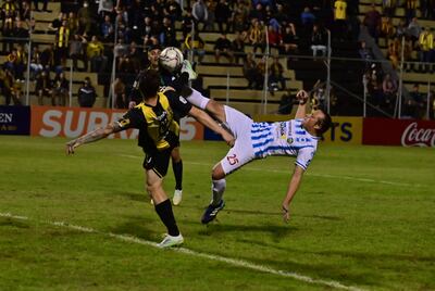 Peligroso cruce de piernas aéreas entre el defensor del 12 de Octubre de Itauguá Sixto Rodrigo Ramírez y el capitán aurinegro Fernando Fernández. El equipo de Robert Pereira golpeó   a Guaraní.